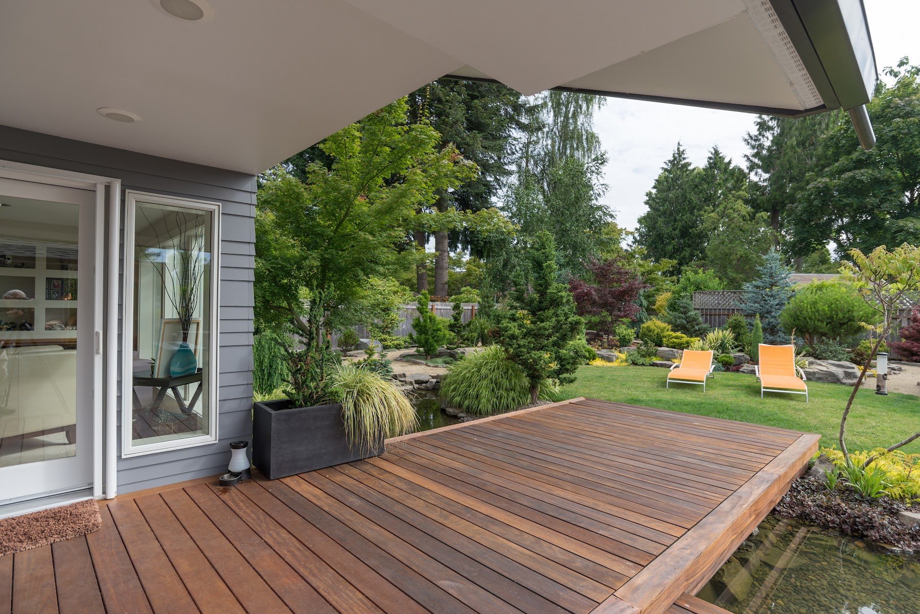 Ground-level wood deck opening to a landscaped backyard