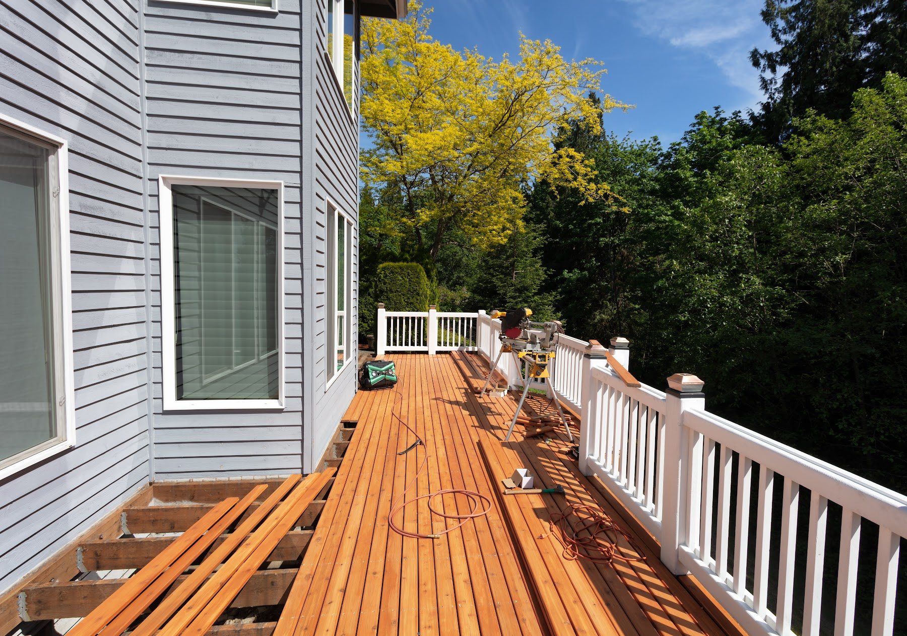Restored wood deck with fresh boards beside a home