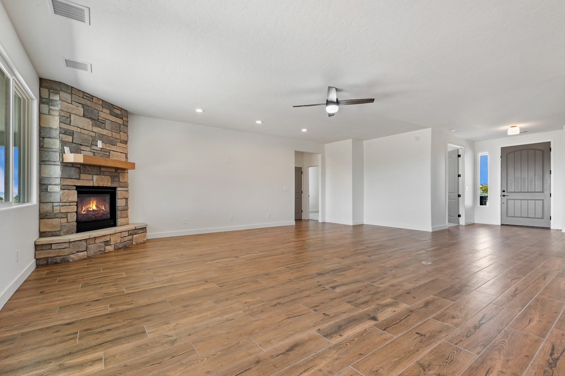 Continuous wood flooring installed through a finished basement room