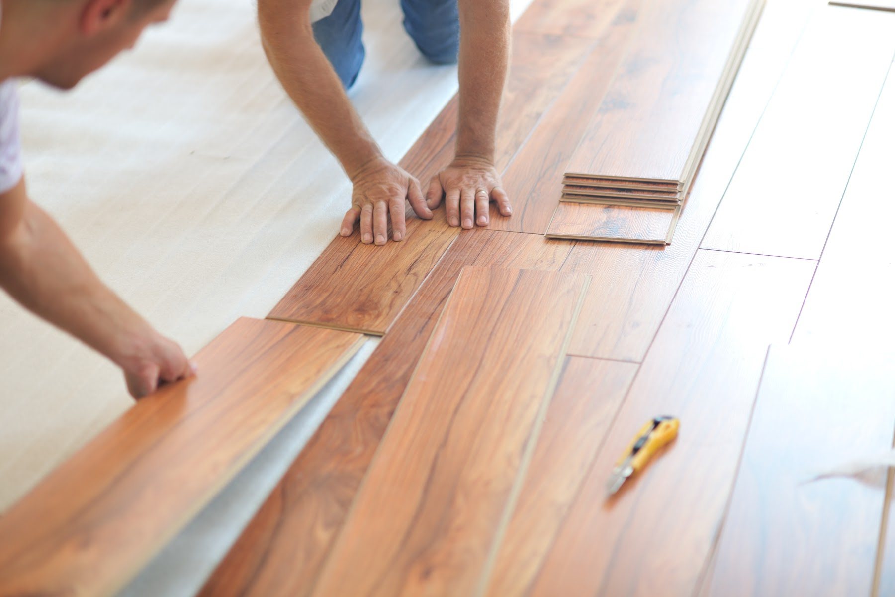 Wood flooring boards being installed and aligned by hand