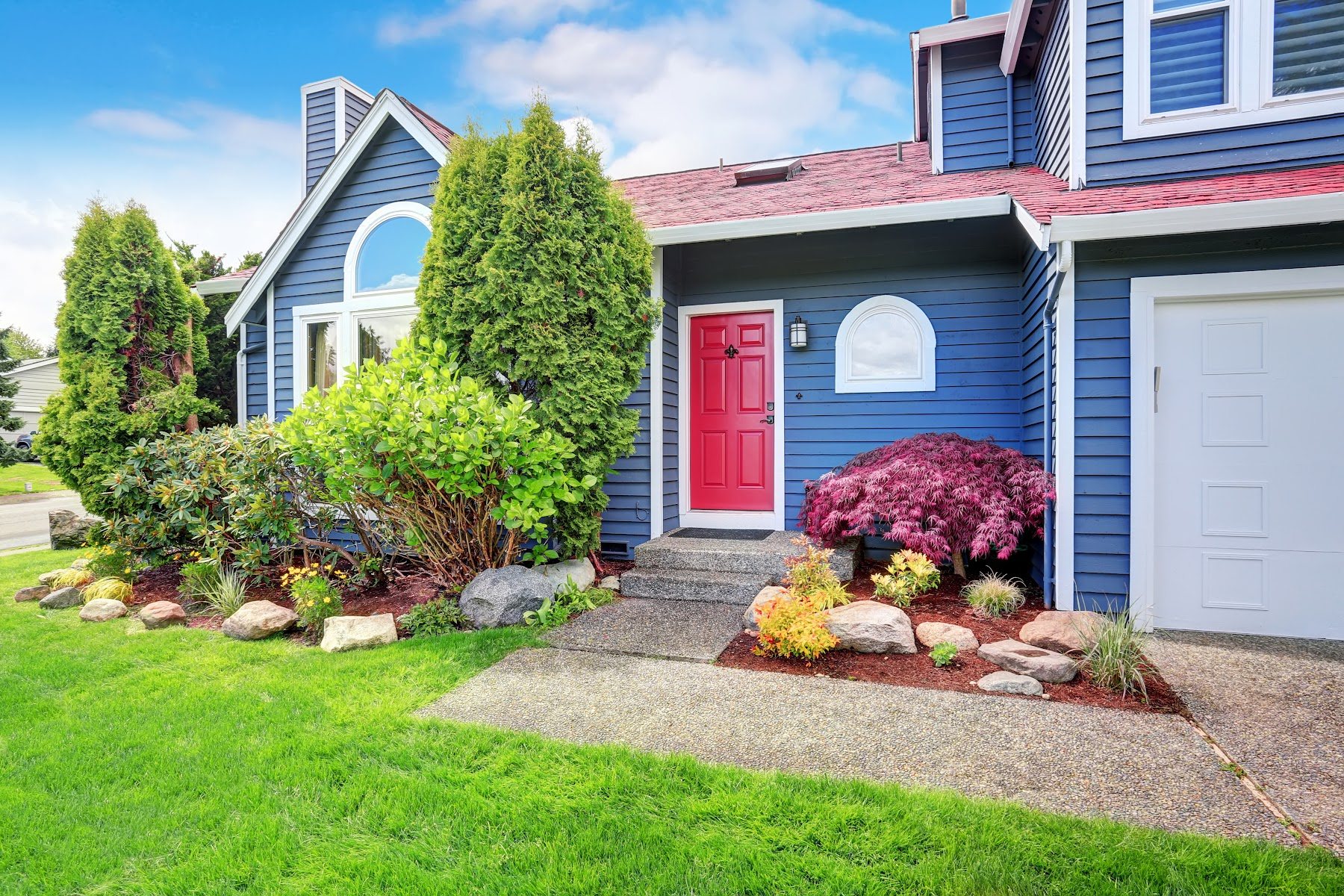 Blue painted home exterior with white trim and red front door