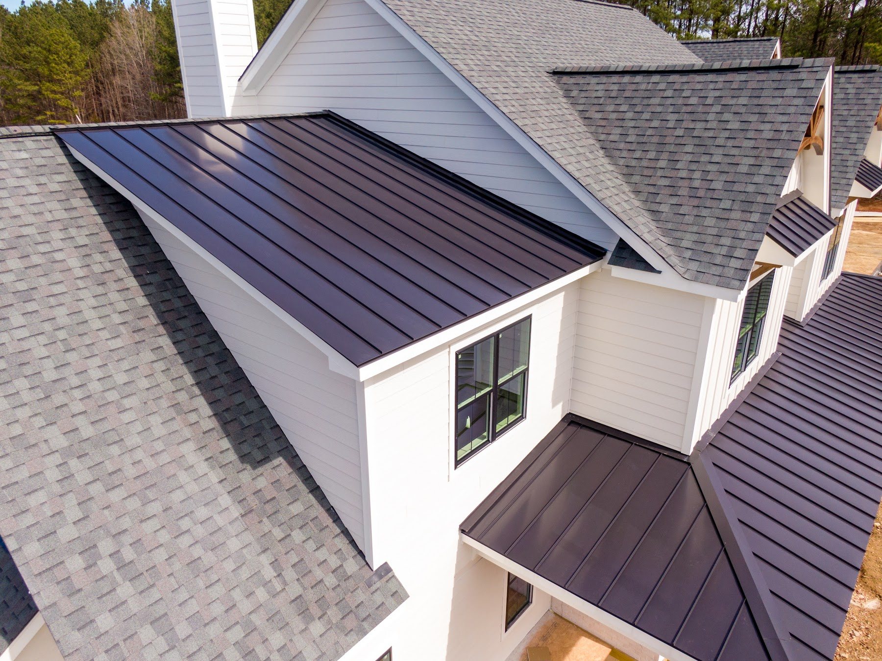 Residential roof combining architectural shingles and standing-seam metal