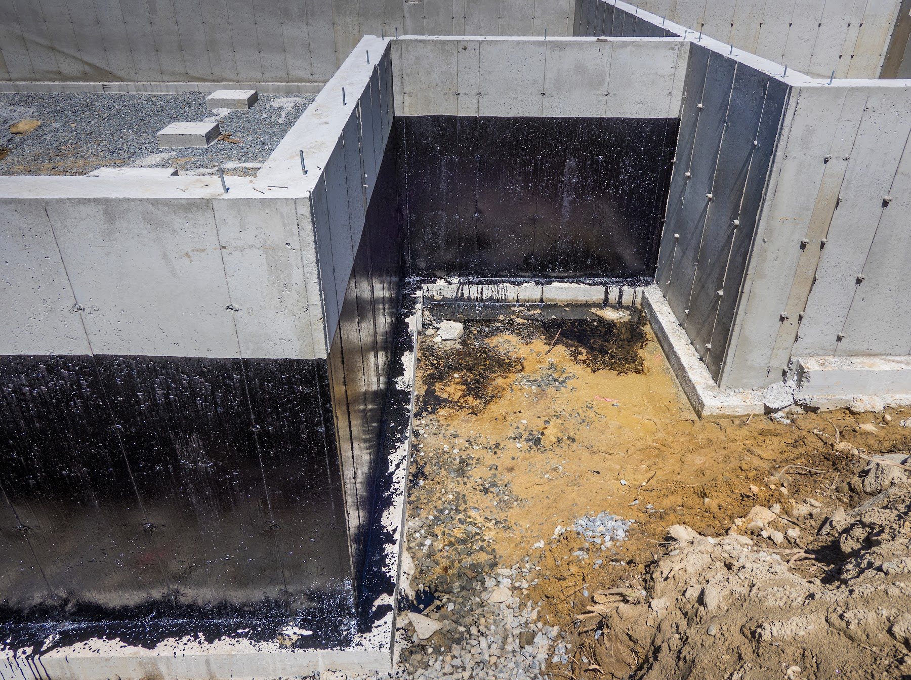 Foundation walls coated with exterior waterproofing membrane