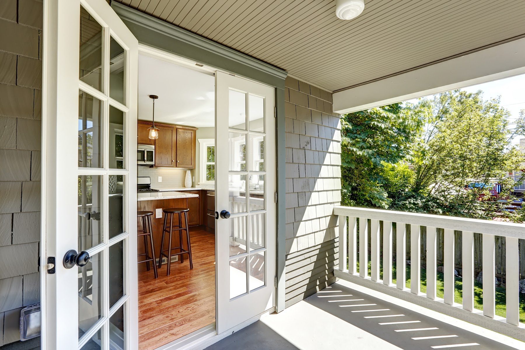 Wide glass doors connecting an interior room to a covered deck