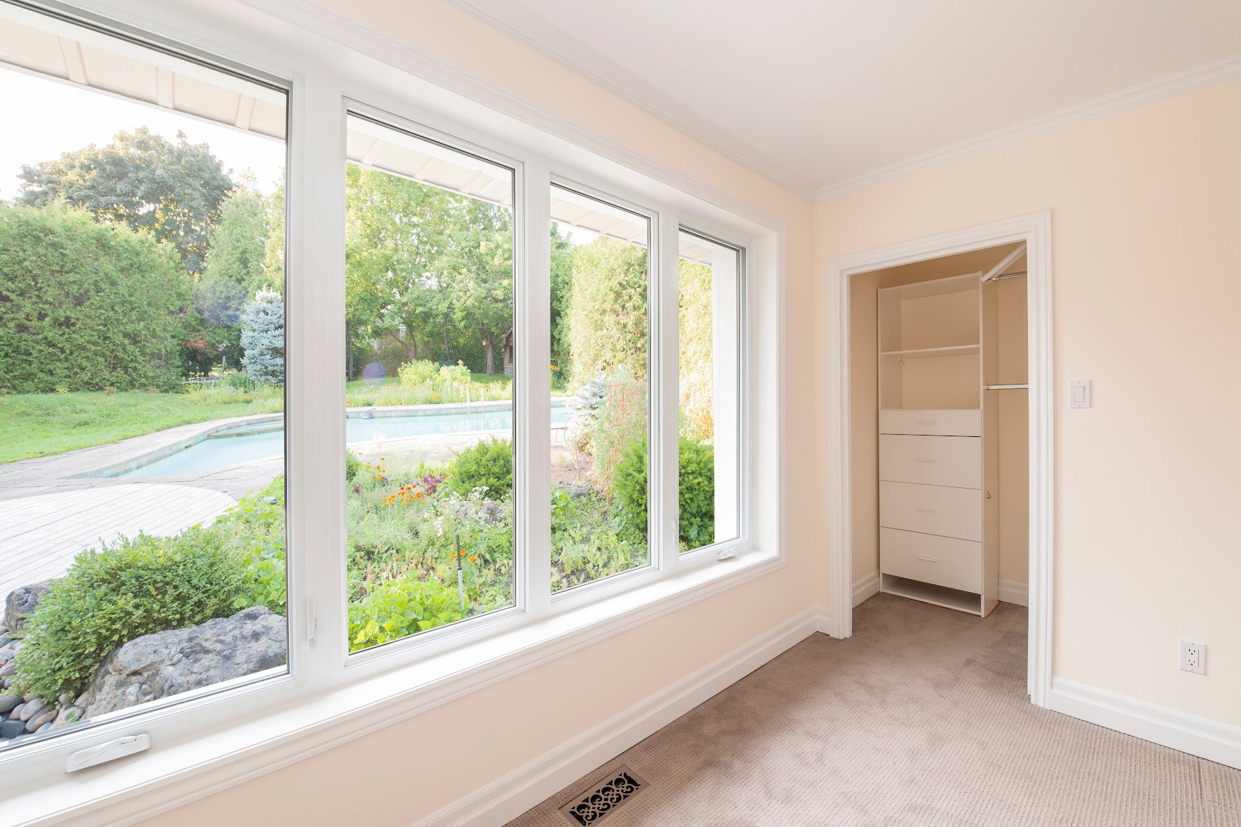 Bay window installation with multiple white-framed glass panels