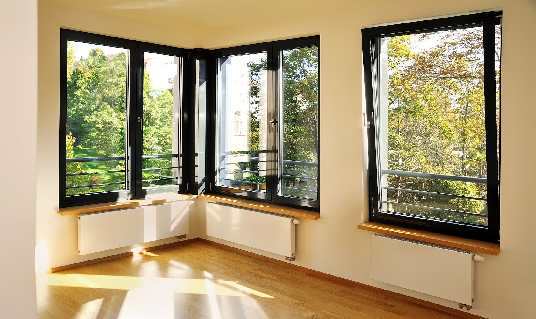 Black-framed corner windows installed in a bright room