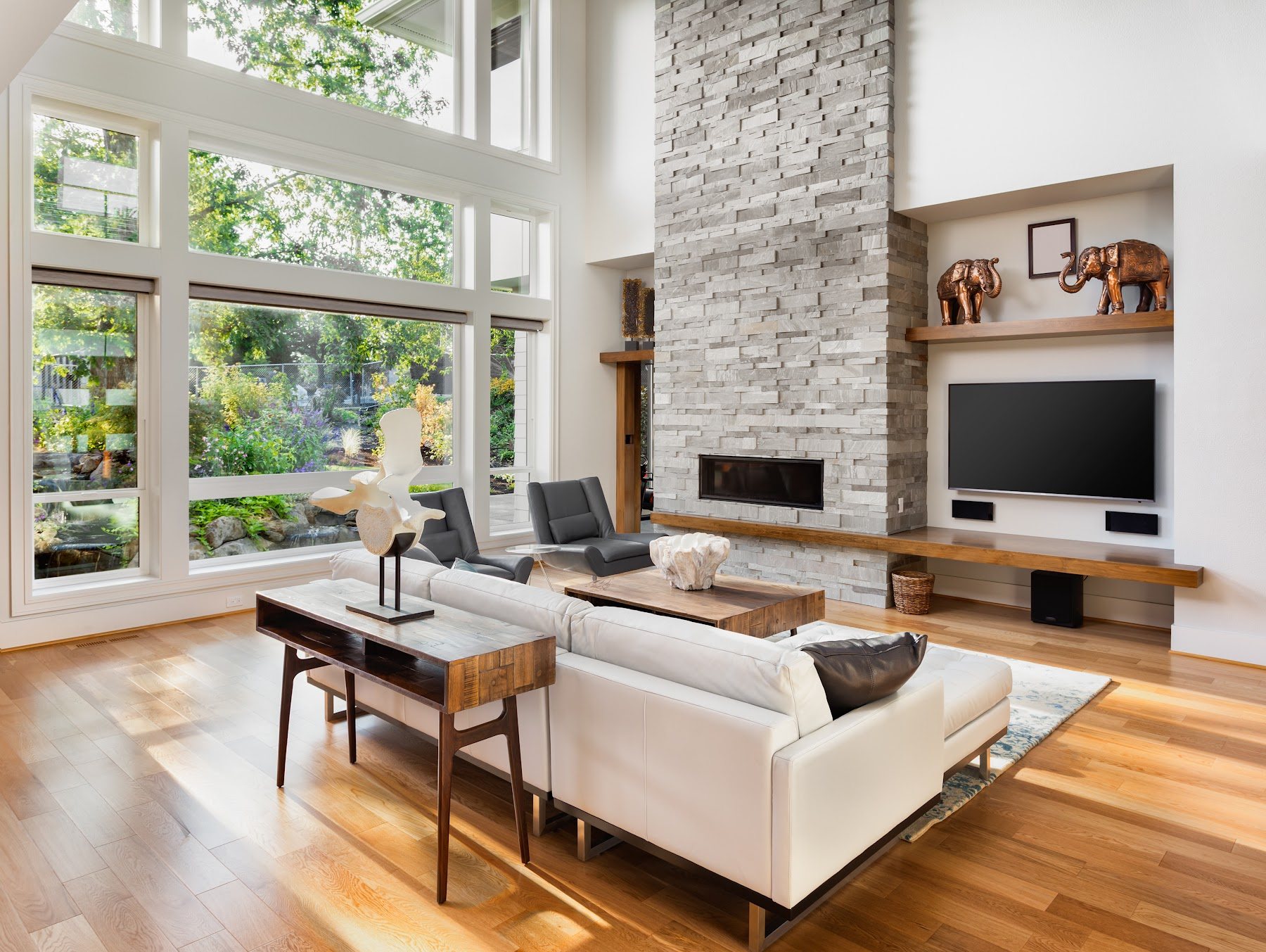 Large white-framed windows beside a stone fireplace