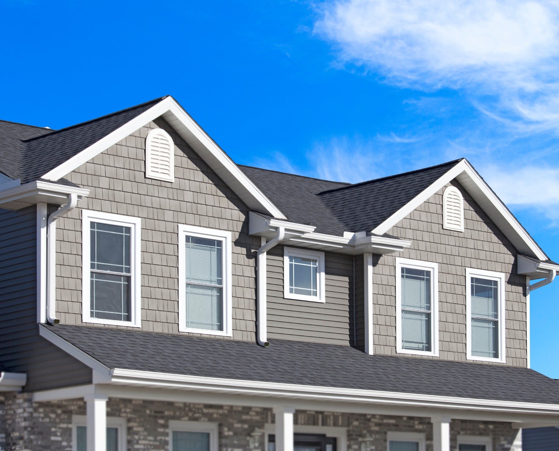 Gray lap and shingle siding with white trim and gutters
